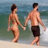 Juliana Paes e o marido, Carlos Eduardo Baptista, andam de mãos dadas na praia