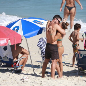 Juliana Paes e o marido, Carlos Eduardo Baptista, se beijam em praia