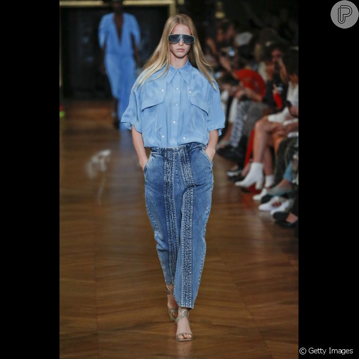 O jeans aparece despojado no verão, combinando com peças mais luxuosas, como a blusa de alfaiataria. Esse look é de Stella McCartney