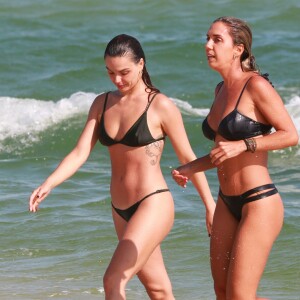 De biquíni verde musgo, Isis Valverde entrou no mar com amiga no Rio de Janeiro