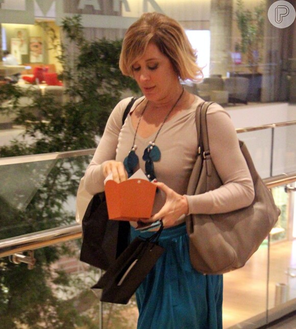 Claudia Raia come pipoca durante passeio em shopping