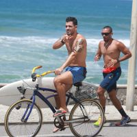 Juliano Cazarré passeia de bicicleta na praia após fazer plástica nas orelhas