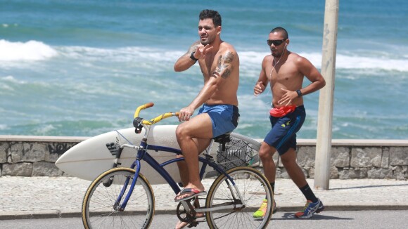 Juliano Cazarré passeia de bicicleta na praia após fazer plástica nas orelhas
