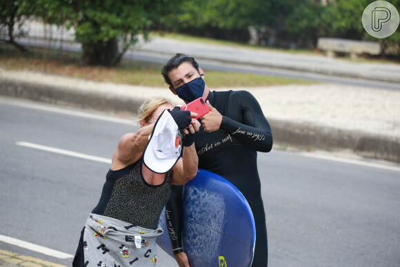Cauã Reymond é abordado por fã e posa para selfie na praia

