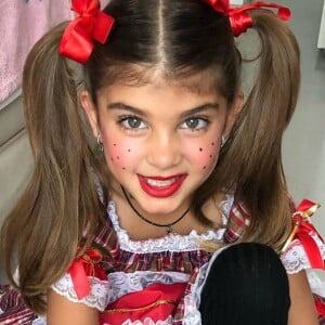 Filha de Grazi Massafera usa look colorido e maquiagem típica