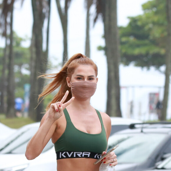 Deborah Secco, com look fitness, acena para fotógrafo ao sair da academia