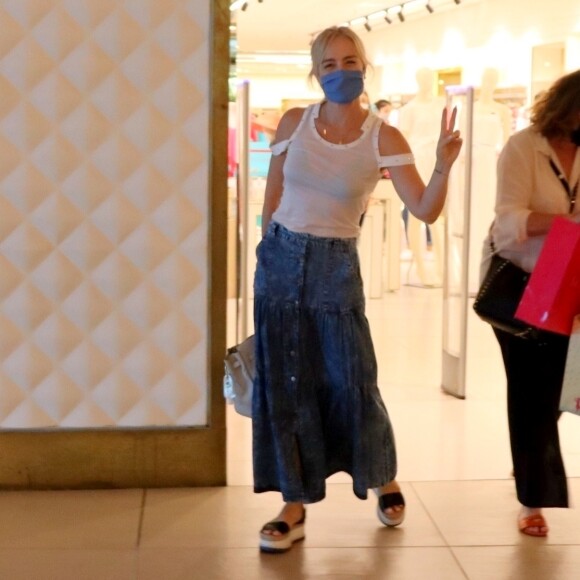 Angélica acena para fotógrafo ao fazer compras em shopping no Rio de Janeiro