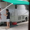 Chay Suede conversa com integrante da equipe de produção antes de gravar comercial na praia de São Conrado