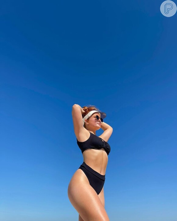 Biquíni cintura alta cavado com top bandeau: Larissa Manoela curte peças maiores para se divertir e jogar altinha na praia com mais conforto
