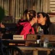 Maria Maya e Amanda Labrego trocaram beijos e carinhos sentadas à mesa de um quiosque