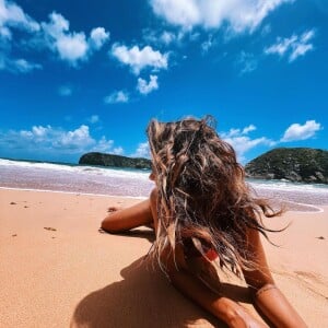 De biquíni, Giovanna Lancellotti deita de bruços nas areias de Fernando de Noronha