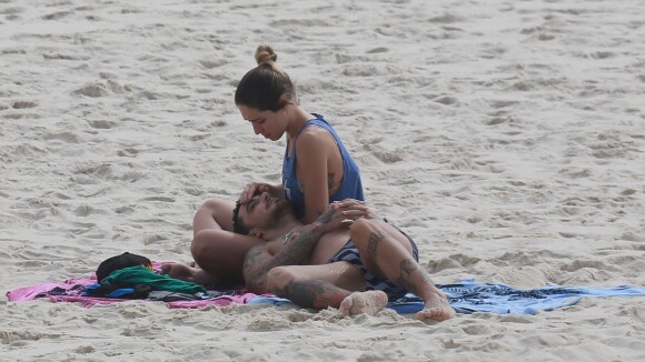 Felipe Titto e a mulher namoram nas areias da praia em dia de sol no Rio