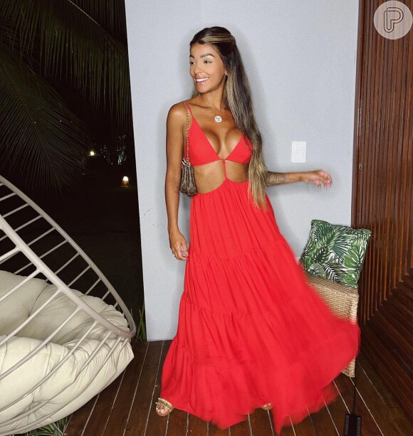 Brunna Gonçalves posa com vestido recortado na cintura em tom vibrante de vermelho