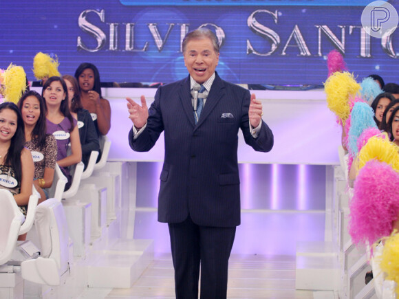 Silvio Santos com os cabelos levemente grisalhos faz uma de suas poses características