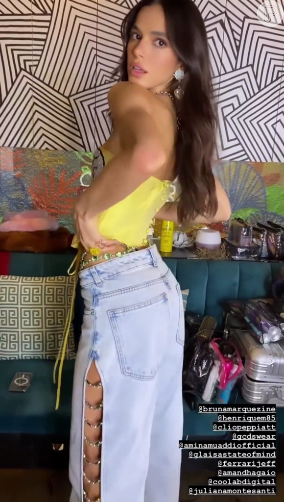 Bruna Marquezine traja calça jeans com fendas laterais, detalhe de tachas prateadas e modelagem ampla