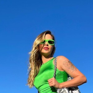 O vestido verde e bem ajustado ao corpo foi combinado com bolsa metalizada e tamancos por Andressa Suita