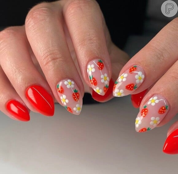 Unhas vermelhas com nail art de flores e morangos é uma opção para quem ama nail arts delicadas
