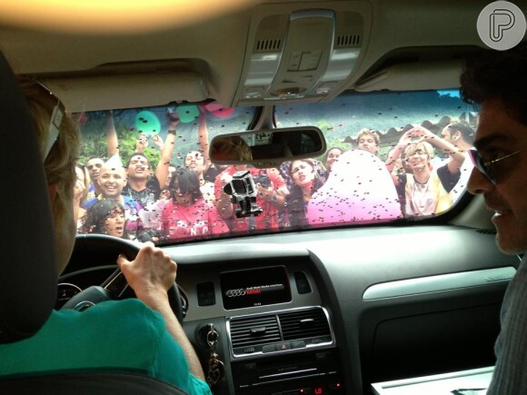 Xuxa chega ao Projac para gravar seu programa especial de aniversário acompanhada do namorado, Junno Andrade, e o carro da loira é cercado por fãs; o casal é clicado por uma pessoa no banco de trás, que publica a foto na página oficial da apresentadora no Facebook, em 25 de março de 2013