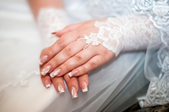 Unhas decoradas com floral e esmalte branco são perfeitas para usar em casamento