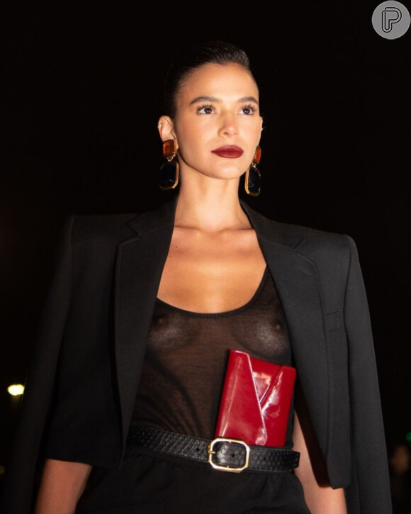 Bruna Marquezine já usou look com transparência all black e uma carteira vermelha