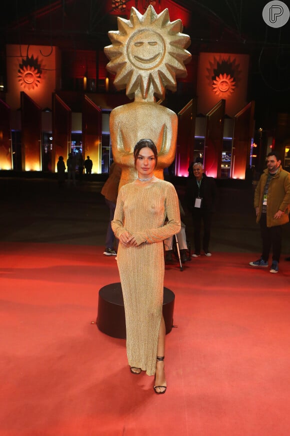 Isis Valverde foi ao Festival de Gramado com um vestido dourado que deixou seus seios à mostra. No look a atriz usou salto ao preto e joias prateadas