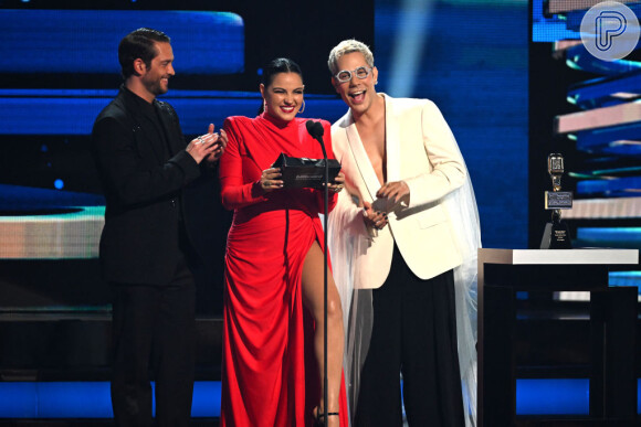 Maite Perroni colocou a perna para jogo ao usar um vestido vermelho com fenda em apresentação nos Premios Billboard Latin