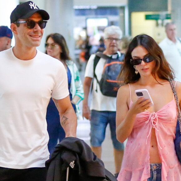 Jeans solto foi aposta de Isis Valverde para embarcar em aeroporto do Rio de Janeiro com o noivo, Marcus Buaiz