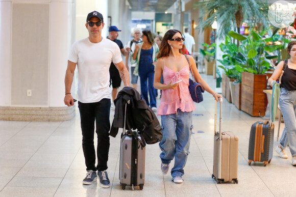 Jeans soltinho compos aerolook de Isis Valverde para embarcar em aeroporto do Rio de Janeiro com o noivo, Marcus Buaiz