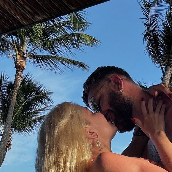 Em uma das fotos, Karoline Lima valorizou seu bumbum em um biquíni fio-dental enquanto beijava Léo Pereira