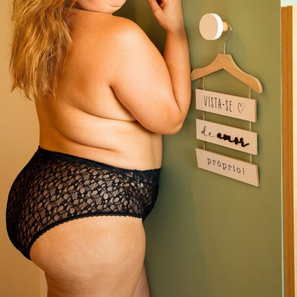 Com um sorriso largo, Mariana Xavier posou ao lado de uma placa escrita "vista-se de amor próprio"