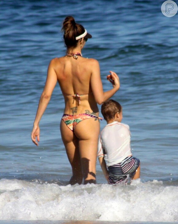 Fernanda Lima entra no mar com o filho