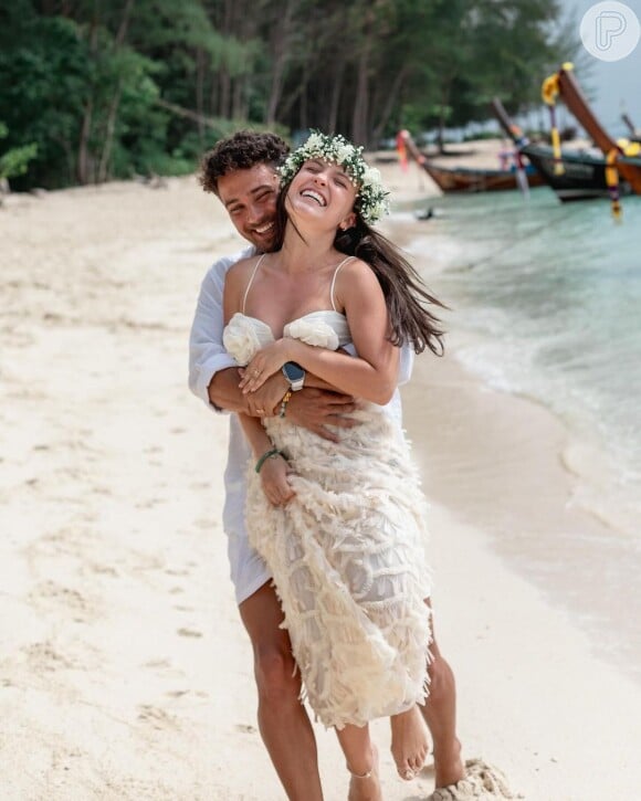 De biquíni, Larissa vestiu uma coroa de flores e carregou um buquê de rosas, enquanto as alianças de concha adicionavam um toque praiano ao evento.