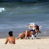 Glenda Koslowski lê jornal enquanto pega um solzinho na praia