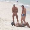 Rodrigo Lombardi exibe barriga tanquinho enquanto brinca com amigo na praia da Barra da Tijuca, no Rio