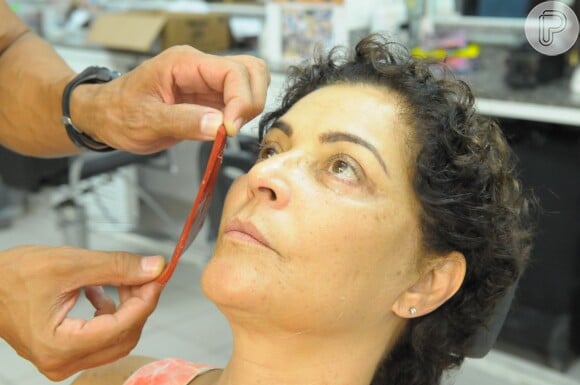 Em seguida, o maquiador utiliza novamente a forma plástica nas maçãs do rosto de Angelina Muniz