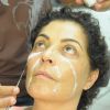 Em seguida, o maquiador passa um material que irá realçar as falsas rugas no rotsto de Angelina Muniz