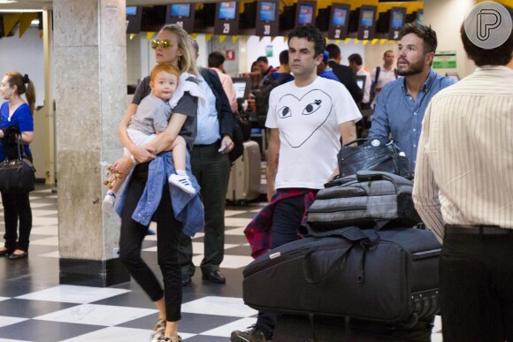 Carol Trentini embarcou em São Paulo ao lado do filho e do marido, o fotógrafo Fabio Bartelt, que empurrou a bagagem da família