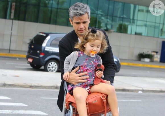 Cuidadoso com a pequena, Otaviano Costa não tirou os olhos de Olivia e segurou a menina durante o percurso até o carro