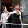 Taylor Swift acena para fãs ao sair da estação de rádio NRJ, em Paris