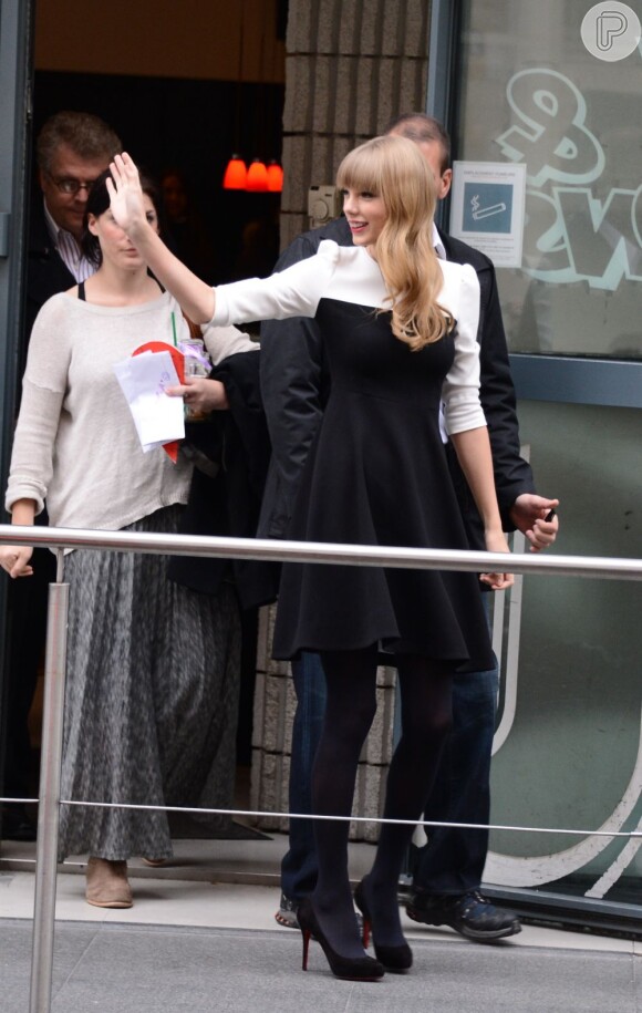 Taylor Swift acena para fãs ao sair da estação de rádio NRJ, em Paris