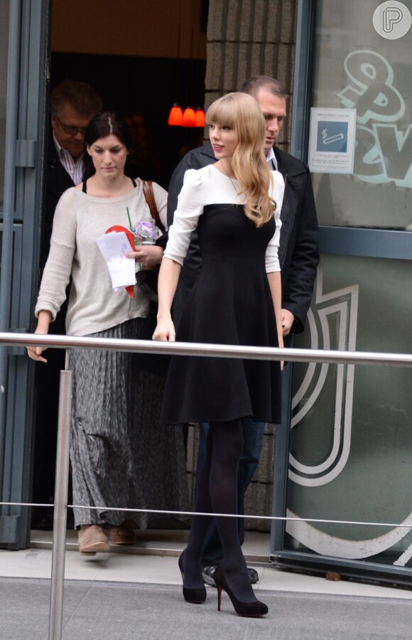Taylor Swift olha para os fãs ao sair da estação de rádio NRJ, em Paris