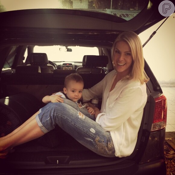 Mãe e filho se divertem em qualquer lugar, até mesmo no porta-malas do carro.