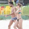 A atriz impressiona pela boa forma de biquíni em uma praia carioca na companhia de um amigo