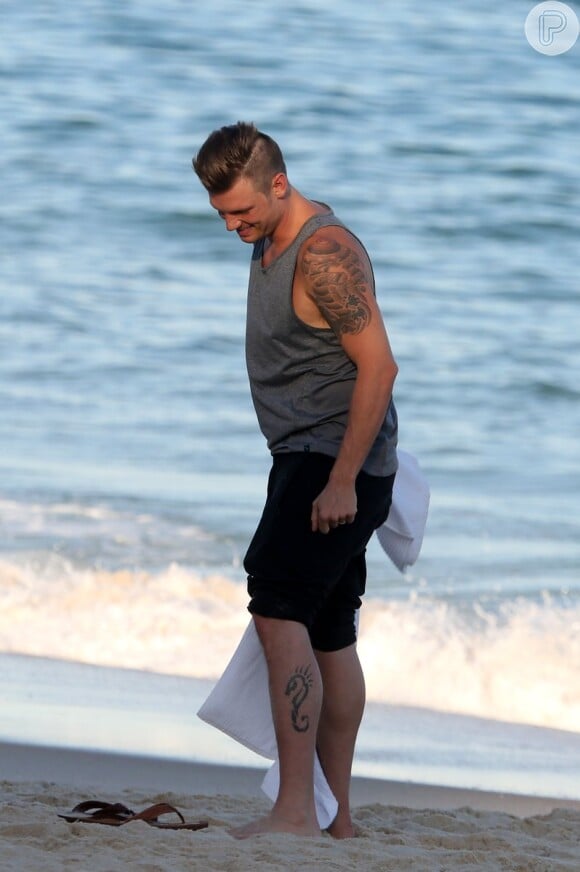 O cantor Nick Carter, do Backstreet Boys, deixou os chinelos de lado para aproveitar a areia da praia do Leblon, zona sul do Rio de Janeiro