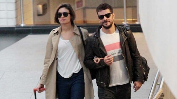 Sophie Charlotte e Daniel de Oliveira caminham de braços dados por aeroporto