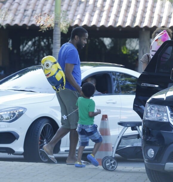 Lázaro Ramos segurou a mão do filho, João Vicente, antes do pequeno entrar no carro com seu balão dos Minions