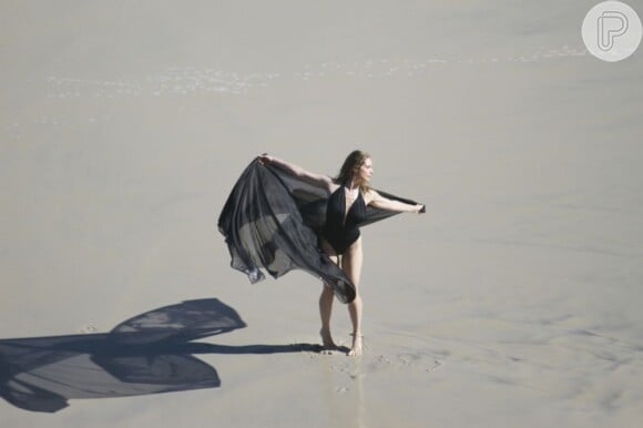Letícia Spiller posou também na areia, onde apareceu com um maiô preto e um lenço da mesma cor