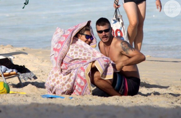 Fernanda Lima e Rodrigo Hilbert se protegeram do frio de fim de tarde da praia do Leblon, Zona Sul do Rio, fazendo uma cabaninha com um lençol, nesta quinta-feira, 11 de julho de 2013
