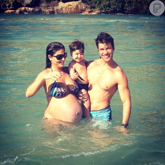 Juliana Paes publica foto em que aparece de biquíni exibindo o barrigão ao lado do filho e do marido, em 20 de julho de 2013
