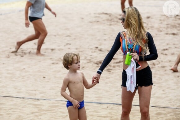 Danielle Winits dá a mão ao filho na pool party